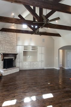 an empty living room with wood flooring and exposed ceiling beams is pictured in this image