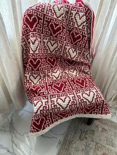 a red and white blanket sitting on top of a chair