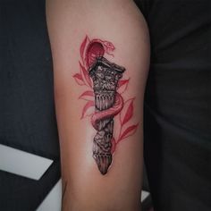 a tattoo on the arm of a woman with a snake wrapped around it