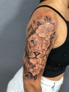 a woman with a lion and roses tattoo on her arm