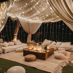 a living room with lights strung over the ceiling and pillows on the floor in front of it