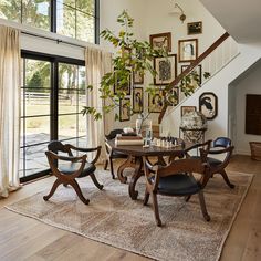 a dining room table with four chairs and a plant in the corner on top of it