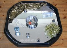 an overhead view of a clock on a wooden table with silver foil covering the top