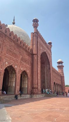 people are walking around in front of an ornate building with arches and minarets