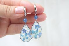 "Real flower earrings with kyanite gemstone. Summer gift for those who are dear to us. If you're throwing a garden wedding set against a backdrop of fresh florals and luscious greenery, then these pretty drop earrings are a no-brainer. Floral earrings work for just about everyone and every theme. even better.  Floral statement earrings are one of those accessories you'll get tons of use out of post \"I dos\" as well. ♥ S H I P P I N G ♥ We ship this jewelry to you free of charge throughout the US, carefully and lovingly packaged and tracked. Optionally, we can gift wrap your order, to which we are also happy to add a personal message from you. ♥ P R O D U C T I O N ♥ Each piece is traditionally handcrafted with the highest precision and quality in our studio in Egg Harbor Township, NJ (USA Elegant Flower Teardrop Earrings For Gift, Elegant Flower Shaped Teardrop Earrings, Silver Earrings With Pressed Flowers For Wedding, Silver Wedding Earrings With Pressed Flowers, Wedding Silver Earrings With Pressed Flowers, Blue Flower Charm Jewelry As Gift For Her, Elegant Blue Pressed Flower Earrings, Elegant Pressed Flowers Earrings For Mother's Day, Handmade Blue Flower Earrings For Wedding