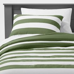 a bed with green and white striped sheets