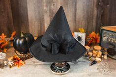 This low profile petite style witch hat is made of a black colored, eco-friendly felt. It has a black velvet band and a matching detachable black bow. Options to add a splash of color to match your witchy apparel. Its circular brim is narrow and the pointy cone is much shorter than your average witch hat, giving it a unique appeal. It's not an "in your face" hat. Inspired by the ancestors who hid in plain sight it's an ode to a classic style hat.  It offers a cottage core vibe and would be a gre Black Witchy Hat For Halloween, Black Brimmed Hat For Costume, Black Brimmed Witchy Costume Hat, Black Brimmed Halloween Hat, Witchy Black Brimmed Costume Hat, Black Halloween Top Hat With Short Brim, Black Witchy Brimmed Costume Hat, Witchy Black Costume Hats And Headpieces For Fall, Black Brimmed Hat For Halloween