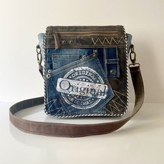 Urban Style Upcycled Denim Crossbody Bag. This eco-friendly unisex messenger bag blends the carefree elegance of a boho purse with a practical design. Each handmade bag showcases the rugged, casual beauty of upcycled denim, making it an ideal travel companion for those who treasure unique style and durability. Embrace the versatility of a shoulder bag with the earth-conscious statement of an eco-friendly bag. Perfect for anyone on the go, this denim purse is not just a fashion statement—it's a c Vintage Denim Shoulder Bag For Travel, Vintage Denim Blue Travel Bag, Travel Shoulder Bag In Medium Wash Rectangular Shape, Rectangular Medium Wash Shoulder Bag For Travel, Trendy Upcycled Shoulder Bag For Everyday, Upcycled Denim Travel Bag, Denim Travel Bag With Upcycled Material, Upcycled Medium Wash Denim Shoulder Bag For Everyday Use, Upcycled Medium Wash Shoulder Bag For Everyday Use