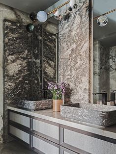 a bathroom with marble counter tops and two sinks in front of a large mirror on the wall