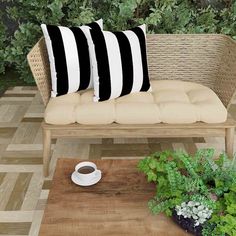 a couch with two black and white pillows sitting on top of it next to a wooden table