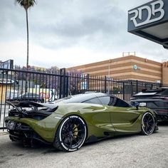 a green sports car parked in front of a building