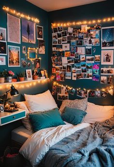 a bed with lots of pictures on the wall and lights strung from it's headboard