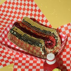 a hot dog with mustard and ketchup sitting on a checkered tablecloth