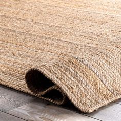 an area rug on the floor that is made out of jute and wood planks