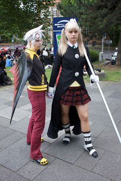 two women dressed in costumes standing next to each other