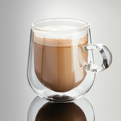 a glass mug filled with liquid sitting on top of a table