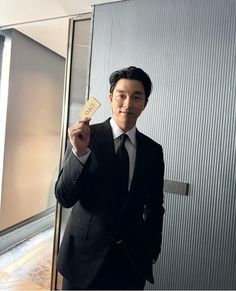 a man in a suit holding up a card