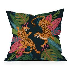 a pillow with two tigers on it and tropical leaves around the edges, in blue