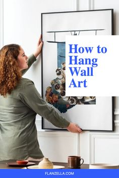 a woman is hanging pictures on the wall in her living room with text overlay that reads how to hang wall art