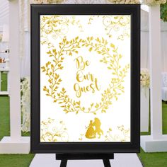 a sign that says be our guest in front of a gazebo with white flowers and greenery