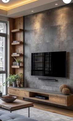 a living room with a large tv on the wall next to a couch and coffee table