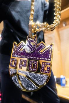 a close up of a person wearing a necklace and holding a basketball ball on a chain