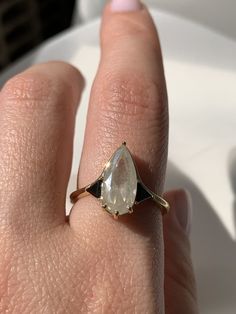 a woman's hand with a yellow and white diamond ring on her left finger