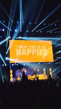 a large sign that says i want you to be happy in front of a crowd