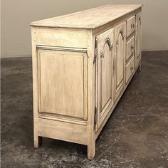 an old white wooden cabinet sitting on top of a floor