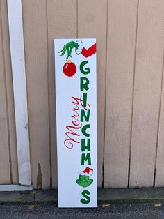 a white sign with green and red lettering on it next to a building door that says grino