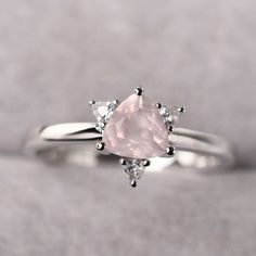 ◆ The ring is handcrafted from sterling silver and decorated with a dazzling 6*6 mm rose quartz and CZs. It is suitable for engagement/anniversary/daily occasion. ◆ Production Description: Main stone Type: Natural Rose Quartz Main Stone Shape: Trillion Cut Main Stone Size: 6*6 mm(0.85ct) Side stone: CZ Metal: 925 Sterling silver - Other options available in the drop down menu ◆ Customization: √Free for Add Engraving √Other Metal Type Available √Other Gemstones & Shapes Available √Personaliza Wedding Rose Gold Birthstone Ring In Sterling Silver, Promise Ring With Rose Quartz And Gemstone Detail, Pink Solitaire Crystal Ring For Wedding, Rose Quartz Crystal Ring For Promise, Pink Sterling Silver Birthstone Ring For Wedding, Elegant Pink Birthstone Ring In Sterling Silver, Elegant Pink Sterling Silver Birthstone Ring, Rose Gold Sterling Silver Crystal Ring For Wedding, Elegant Morganite Crystal Ring For Wedding