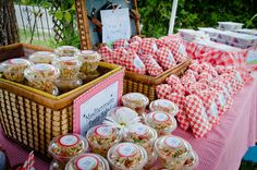 an outdoor picnic with food and snacks on the table in front of it, along with other items for sale