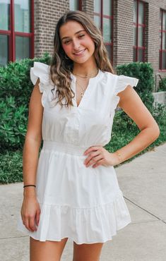 Make every day a game day with our V-Neck Ruffle Romper! This woven, white ruffle romper... looks like a dress - but it actually is lined with shorts - making it as comfortable as it is cute. Show off your team spirit by dressing it up with a game day pin or garnet and gold earrings! Details: Woven, Ruffle Romper Self: 100% Cotton Lining: 100% Polyester Split Neckline, Ruffle Sleeve, Cinched Waist, Ruffle Skirt, Lined with Shorts, Neckline Button Closure Color: White True to size: Student Slim F White Ruffle Sleeve Mini Dress For Daywear, White Mini Dress With Ruffle Sleeves For Daywear, White Casual Mini Dress With Ruffle Sleeves, White Flutter Sleeve Mini Dress For Vacation, White Mini Dress With Ruffle Hem And Sleeve, White Ruffle Sleeve Mini Dress For Beach, White Ruffle Sleeve Mini Dress For Summer, White Mini Dress With Smocked Back For Day Out, White Mini Dress With Ruffle Sleeves For Beach