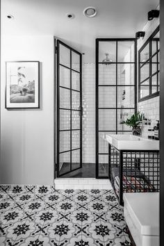 a black and white photo of a bathroom with tile flooring, double doors, and tiled walls