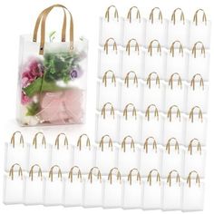 a bag filled with lots of white bags next to some pink and purple flowers in it