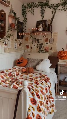 a bedroom decorated for halloween with pumpkins on the bedspread and decorations around the bed