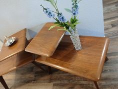 two wooden tables with vases and flowers on them