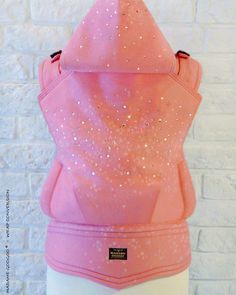 a pink hoodie with sequins on it sitting on a mannequin