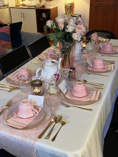 the table is set with pink and gold dishes