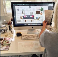 a woman sitting in front of a computer on top of a desk with a keyboard and mouse