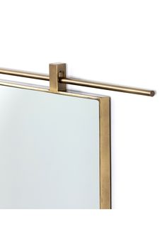 a mirror that is on the wall with a metal bar attached to it's side