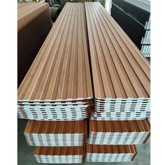 several stacks of wooden boards stacked on top of each other in a warehouse with workers working behind them