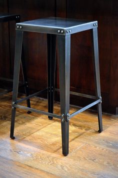 two metal stools sitting on top of a hard wood floor