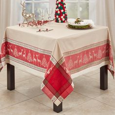 It's time to celebrate the holiday season with this graceful Holiday Jacquard Tablecloth. The tablecloth showcases a delightful Christmas motif of reindeer and Christmas trees, woven into a red and beige color palette. The border features alternating rows of reindeer and trees, symbolizing the joy and warmth of the holiday spirit. The red checkered corner details, accented with subtle snowflakes, add an extra layer of festive charm. Perfect for Christmas dinner parties, holiday brunches, or festive home décor, this versatile tablecloth can also be used for a variety of occasions throughout the winter season. The Holiday Aisle® Size: 70" Square | The Holiday Aisle® Christmas Reindeer Design Jacquard Tablecloth Cotton Blend in Red | 70" Square | Wayfair Holiday Tablescape, Oblong Tablecloth, Waterproof Tablecloth, Holiday Tablescapes, Holiday Table Decorations, Tablecloth Sizes, Rectangle Tablecloth, Square Tablecloth, Christmas Table Cloth