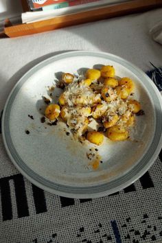 a white plate topped with food on top of a table next to a book shelf