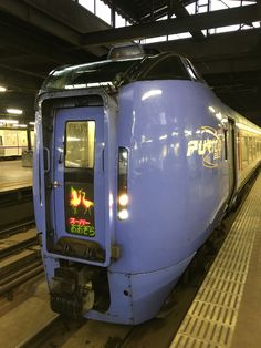 a blue train is stopped at the station