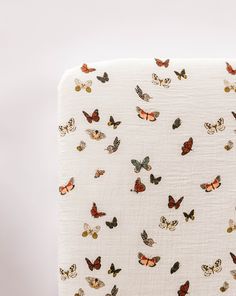 a white blanket with many butterflies on it