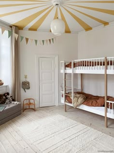 there are bunk beds in the room that is decorated with bunting and garlands