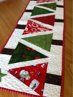 a quilted table runner with christmas trees on it