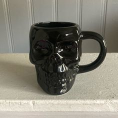 a black skull mug sitting on top of a counter